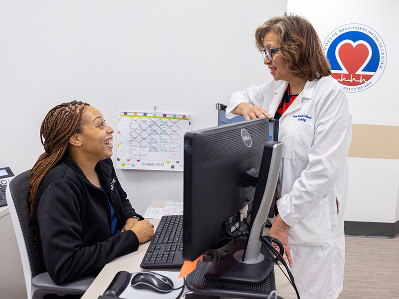 Tameka Roberson, a customer care representative in the Division of Cardiology, chats with Dr. Myrna Alexander, a cardiologist and professor of medicine, where both work in the University Pavilion cardiology clinic.